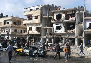 In this photo released by the Syrian official news agency SANA, Syrian citizens gather at the scene where two blasts exploded in the pro-government neighborhood of Zahraa, in Homs province, Syria, Sunday, Feb. 21, 2016.