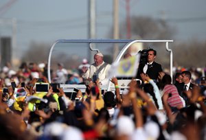 Pope Francis waves at faithful as he arrives for a massive open-air Mass in a park just a few meters from the U.S. border in Ciudad Juarez, Mexico, Wednesday, Feb. 17, 2016.