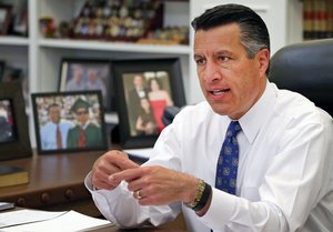 In this April 17, 2015 file photo, Nevada Gov. Brian Sandoval sits in his office at the Capitol in Carson City, Nev.