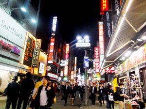 Donned in suits and coats, people stroll along a Shibuya street in Tokyo, Japan.