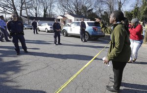 A woman yells at police near the scene of a fatal shooting in Raleigh, N.C., Monday, Feb. 29, 2016.