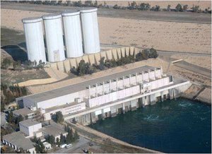 File - The hydroelectric power plant at Mosul Dam with four surge tanks in background, Iraq.