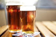 Two glasses of beer on the wooden table in bar.