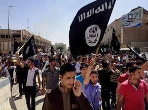 In this Monday, June 16, 2014 file photo, demonstrators chant pro-Islamic State group slogans as they wave the group's flags in front of the provincial government headquarters in Mosul, 225 miles (360 kilometers) northwest of Baghdad, Iraq.