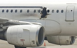 In this Tuesday, Feb. 2, 2016 file photo, a hole is photographed in a plane operated by Daallo Airlines as it sits on the runway of the airport in Mogadishu, Somalia.