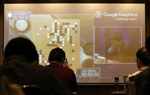 South Korean professional Go player Lee Sedol, right, is seen on the screen during the Google DeepMind Challenge Match against Google's artificial intelligence program, AlphaGo, at the media room in Seoul, South Korea, Wednesday, March 9, 2016.