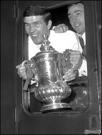 Ron Yeats and Ian St John show off the FA Cup on the train from Euston to Liverpool