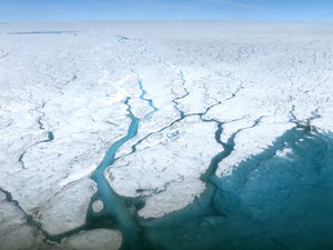 File - Ice water melt streams flow on the Greenland Ice Sheet, July 19, 2015.