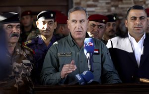 Iraqi Defense Minister Khaled al-Obeidi, centre speaks to reporters at a military a base outside Tikrit, 130 kilometers (80 miles) north of Baghdad, Iraq, Wednesday, March 9, 2016.