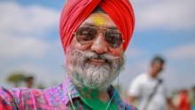 Guri Singh with coloured power all over his face, beard and clothes at a Holi festival in Melbourne.