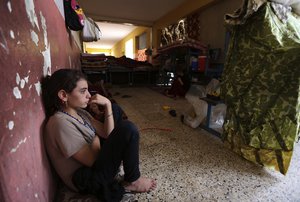 File - An internally displaced Yazidi who fled from an Iraqi town after advances by Islamic militants takes shelter at a school in Dahuk, 260 miles (420 kilometers) northwest of Baghdad, Thursday, Oct. 2, 2014.