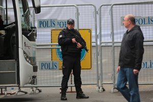 Security officials work at the explosion site, a day after a suicide car bomb went off near bus stops in the heart of Turkey's capital Ankara, Monday, March 14, 2016.