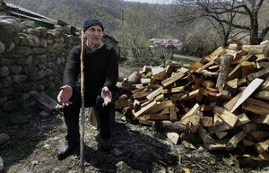 In this April 8, 2015 photo, Temur Batirashvili, the father Tarkhan Batirashvili, aka Omar Al Shishani, sits in a yard outside his house in the village of Duisi, about 70 km (43 miles) north of Tbilisi, in Pankisi Gorge, Georgia.