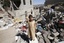 A boy stands in rubble from houses destroyed by Saudi-led airstrikes in Sanaa, Yemen, Friday, May 1, 2015. The UN has said that the indiscriminate bombing of populated areas is against international law.