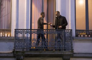 In this Wednesday, Nov. 18, 2015 file photo, Mohammad Abdeslam, left, the brother of Paris attackers Salah and Brahim Abdelslam, lights candles with an unidentified man on the balcony of his house during a candlelight vigil in the town square of Molenbeek, Belgium.