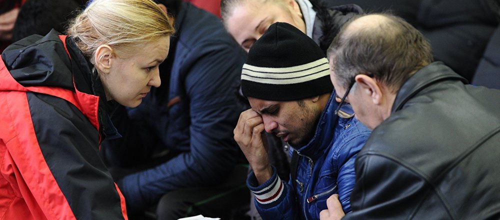 A psychologist of the Russian Emergencies Ministry speaks with a relative of a victim of the crashed Flydubai Boeing 737-800 at the airport of Rostov-On-Don, Russia