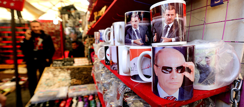 A Syrian vendor sells mugs bearing portraits of Russian President Vladimir Putin (bottom) and Syrian President Bashar Assad (top) in the popular Hamidiyeh market in the old part of the capital Damascus on November 26, 2015