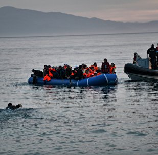 Refugees and migrants massed onto an inflatable boat reach Mytilene, northern island of Lesbos, after crossing the Aegean sea from Turkey on February 17, 2016