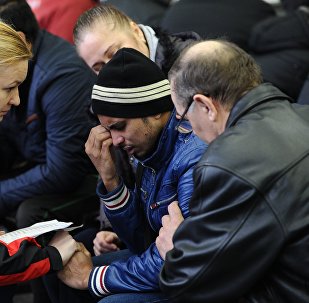 A psychologist of the Russian Emergencies Ministry speaks with a relative of a victim of the crashed Flydubai Boeing 737-800 at the airport of Rostov-On-Don, Russia