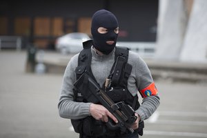 A special forces police officer awaits a convoy and ambulance thought to be carrying captured fugitive Salah Abdeslam outside the federal penitentary in Bruges, Belgium, on Saturday, March 19, 2016.