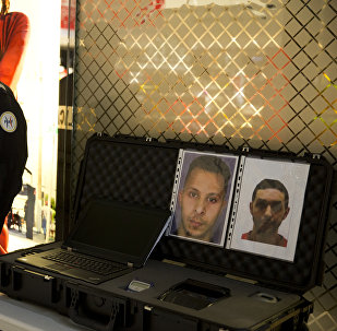 Police officers stand next to the wanted notice of terrorist Salah Abdeslam (L) and Mohamed Abrini on December 3, 2015 at the Roissy-Charles-de-Gaulle airport in Roissy-en-France, outside Paris.