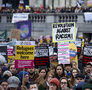 Demonstrators hold banners in support of refugees as they march through central London on March 19, 2016.