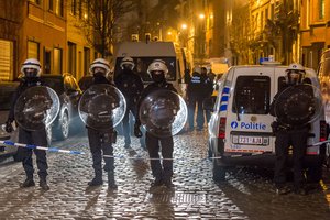 Police officers secure a street during a raid in the Molenbeek neighborhood of Brussels, Belgium, Friday March 18, 2016.