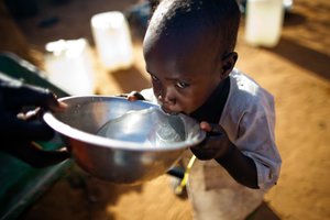 World Water Day - 22 March Two-year-old Ismael Adam receives a drink of water from his kin and caretaker Kariya Mohamed Abbakar, a 50-year-old native of Jebel Saiey, North Darfur, who has been living in the Abu Shouk Camp for internally displaced persons (IDP) near El Fasher for the past 10 years. Mrs. Mohamed Abbakar walks a long distance every week to fetch water from the nearest water point in the camp.