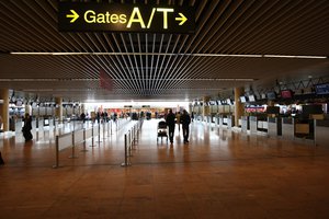 File - Passengers walk along closed check-in counters, at Brussels airport as all outgoing flights were cancelled in Brussels, Thursday April 15, 2010.