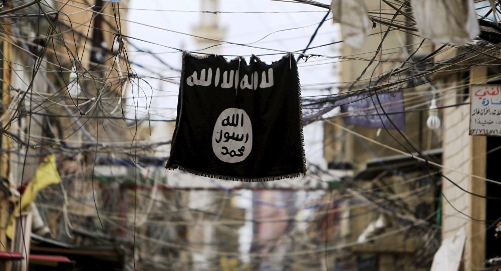 An Islamic State flag hangs amid electric wires over a street.