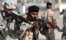 An American military trainer instructs an Iraqi soldier during an exercise on approaching and clearing buildings at the Taji base complex, which hosts Iraqi and US troops and is located north of the capital Baghdad, on January 7, 2015