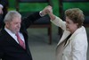 Brazil’s former President Luiz Inacio Lula da Silva and President Dilma Rousseff raise their arms together to celebrate the swearing-in of Silva as the newly-appointed chief of staff, at the Planalto presidential palace, in Brasilia, Brazil, Thursday, March 17, 2016.