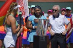 Victoria Azarenka, left, of Belarus, speaks to Serena Williams, as tournament director Raymond Moore stand by after Azarenka defeated Williams in a final at the BNP Paribas Open tennis tournament, Sunday, March 20, 2016, in Indian Wells, Calif. Azarenka won 6-4, 6-4