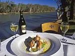 View of the Murray River over plate of food and bottle of wine at Trentham Estate winery restaurant near Mildura. /Victoria