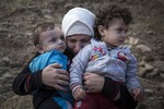 A Syrian mother cries as she hugs her children after spending five hours on a dinghy to approach the Greek island of Lesbos from the Turkish coasts on Wednesday, Sept. 30, 2015.