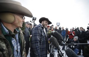 Ammon Bundy, center, one of the sons of Nevada rancher Cliven Bundy, speaks with reporters during a news conference at Malheur National Wildlife Refuge headquarters Monday, Jan. 4, 2016, near Burns, Oregon.