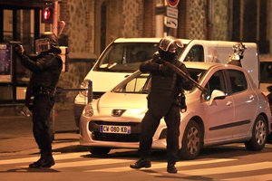 Police officers take up positions in Saint Denis, a northern suburb of Paris, Wednesday, Nov. 18, 2015.