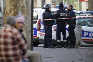 File - Police officers secure the area after a fatal shooting took place at a police station in Paris, Thursday, Jan. 7, 2016.