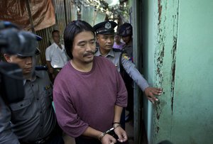 Ethnic Kachin activist Patrick Kum Ja Lee, center, is escorted by police officers during a court hearing in Yangon, Myanmar, Friday, Jan. 22, 2016.