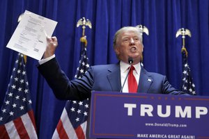 Developer Donald Trump displays a copy of his net worth during his announcement that he will seek the Republican nomination for president, Tuesday, June 16, 2015