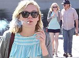 **EXCLUSIVE**  Date: March 26th 2016   Photo Credit: MOVI Inc.\nActress Kirsten Dunst shows off her long legs in a pair of short black hot pants as she enjoys a cosy cigarette and a ugh with a mystery male companion after breakfast in Studio City,CA.