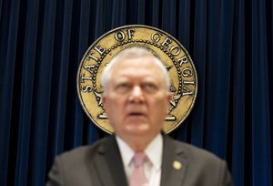 The seal of the state of Georgia hangs behind Gov. Nathan Deal as he speaks during a press conference to announce he has vetoed legislation allowing clergy to refuse performing gay marriage and protecting people who refuse to attend the ceremonies Monday, March 28, 2016, in Atlanta. The Republican rejected the bill on Monday, saying,