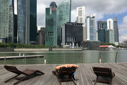 A man rests on a deck chair facing the financial district of Singapore on Thursday, Jan. 14, 2016. Singapore, which is about the size of New York City, has a population of more than 5 million and its economy relies mainly on finance, tourism and manufacturing. (AP Photo/Wong Maye-E)