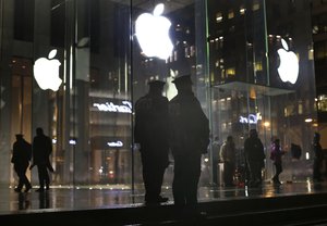 New York police officers stand outside the Apple Store on Fifth Avenue while monitoring a demonstration, Tuesday, Feb. 23, 2016, in New York.