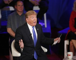 Republican presidential candidate, Donald Trump holds a piece of paper as he talks about a statement from a Breitbart News reporter during a CNN town hall with Anderson Cooper in the historic Riverside Theatre, Tuesday, March 29, 2016, in Milwaukee.