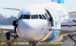 A man, leaves the hijacked aircraft of Egyptair from the pilot's window after landing at Larnaca airport Tuesday, March 29, 2016.