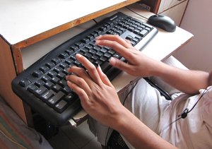 A girl operating computer keyboard for internet - India