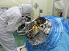 An instrument scientist inspects the Soft X-ray Spectrometer before its final closing. The SXS is one of four payloads flying on the Japanese-led Hitomi mission launching in February.