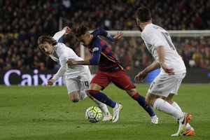 Barcelona's Neymar, center, runs with the ball alongside Real Madrid's Luka Modric, left, during a Spanish La Liga soccer match between Barcelona and Real Madrid, dubbed 'el clasico', at the Camp Nou stadium in Barcelona, Spain, Saturday, April 2, 2016.