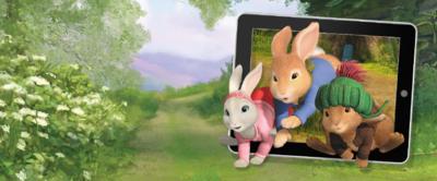 Peter Rabbit, Benjamin Bunny and Lily hopping in front of a tablet device